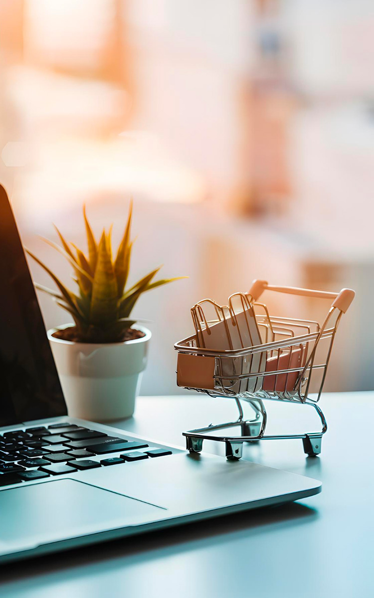 Laptop with a mini supermarket trolley on a desk